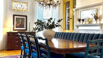 A teal velvet banquette, brass chandeliers, and a table that begs for a long dinner