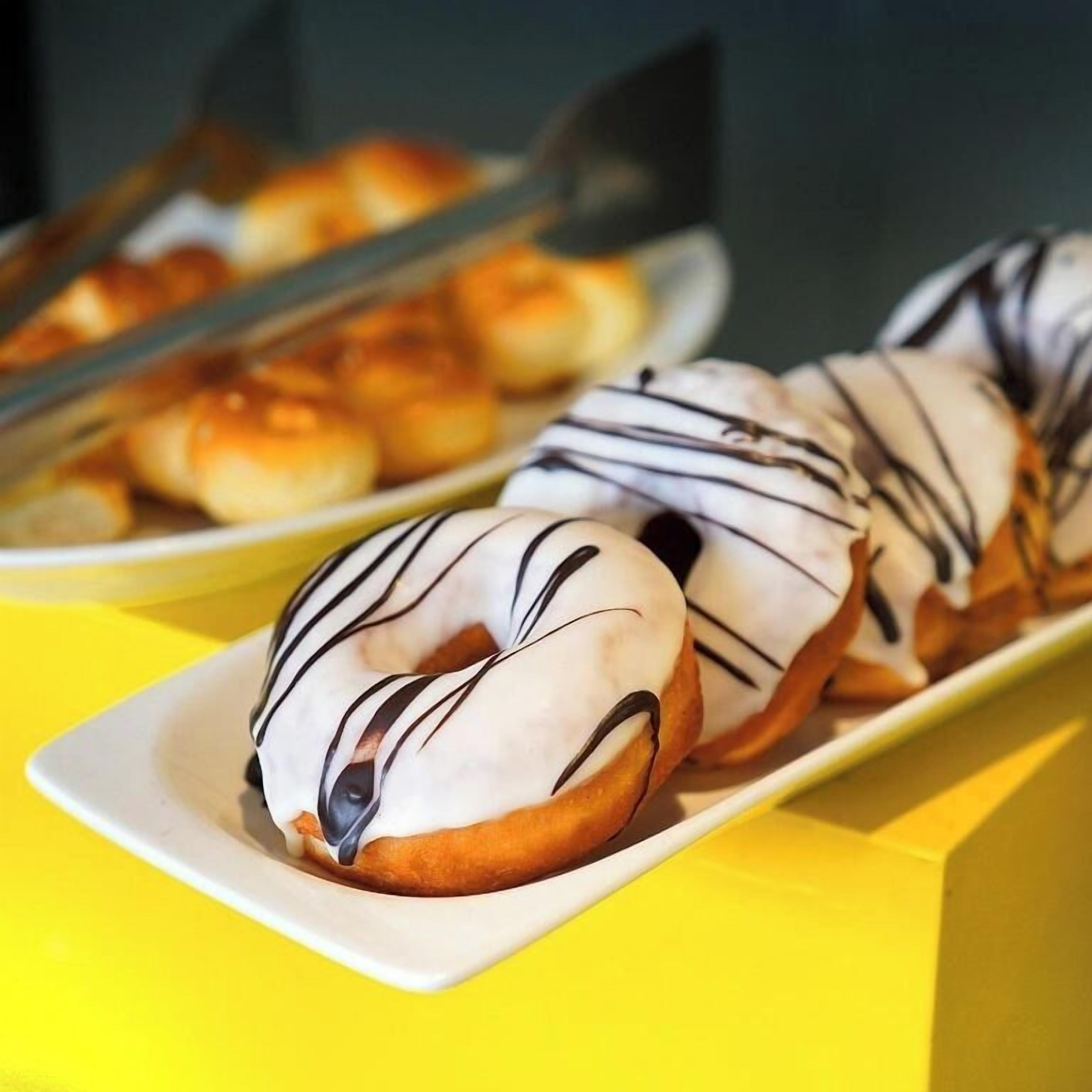 A tray of glazed donuts on a white plate.