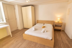 A bedroom with a bed, a wardrobe, a desk, and a nightstand. - Casa Cecilia Ascona 500m From the Lake (Ascona)