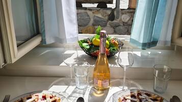 Una mesa dispuesta con dos porciones de tarta de fruta, una botella de vino y copas.