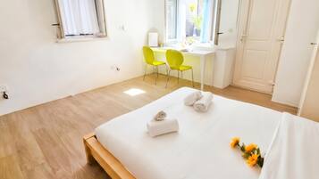 Een hotelkamer met een bed, twee stoelen, een bureau en een raam.