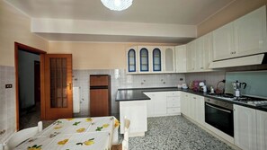 A compact kitchen with a refrigerator, stove, and sink.