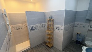 A bathroom with a shower, a wooden shelf, and a toilet. - Vanila Dream's House (Palermo)