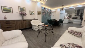A modern living room with a sofa, armchair, and dining area with chairs. - Vanila Dream's House (Palermo)
