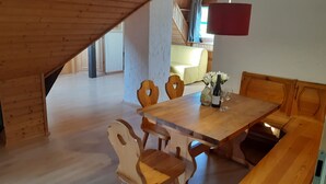 A dining area with a wooden table, chairs, and a bench. - Apartment 'Kopffrei on 1000 m² /Apartment 2 with Shared Garden, Balcony & Wi-Fi (Feldberg (Schwarzwald))