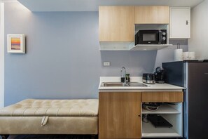 A compact kitchen with a microwave, coffee maker, and a refrigerator. - Beachside 1BR•Walk to Rawai•Cozy-title rawai C201 (ตำบล ราไวย์)