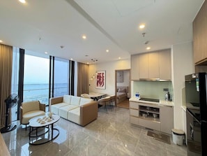 A modern hotel room with a living area, dining space, and kitchenette. - Apartment in Icon 40 Ha Long   (Bai Chay)