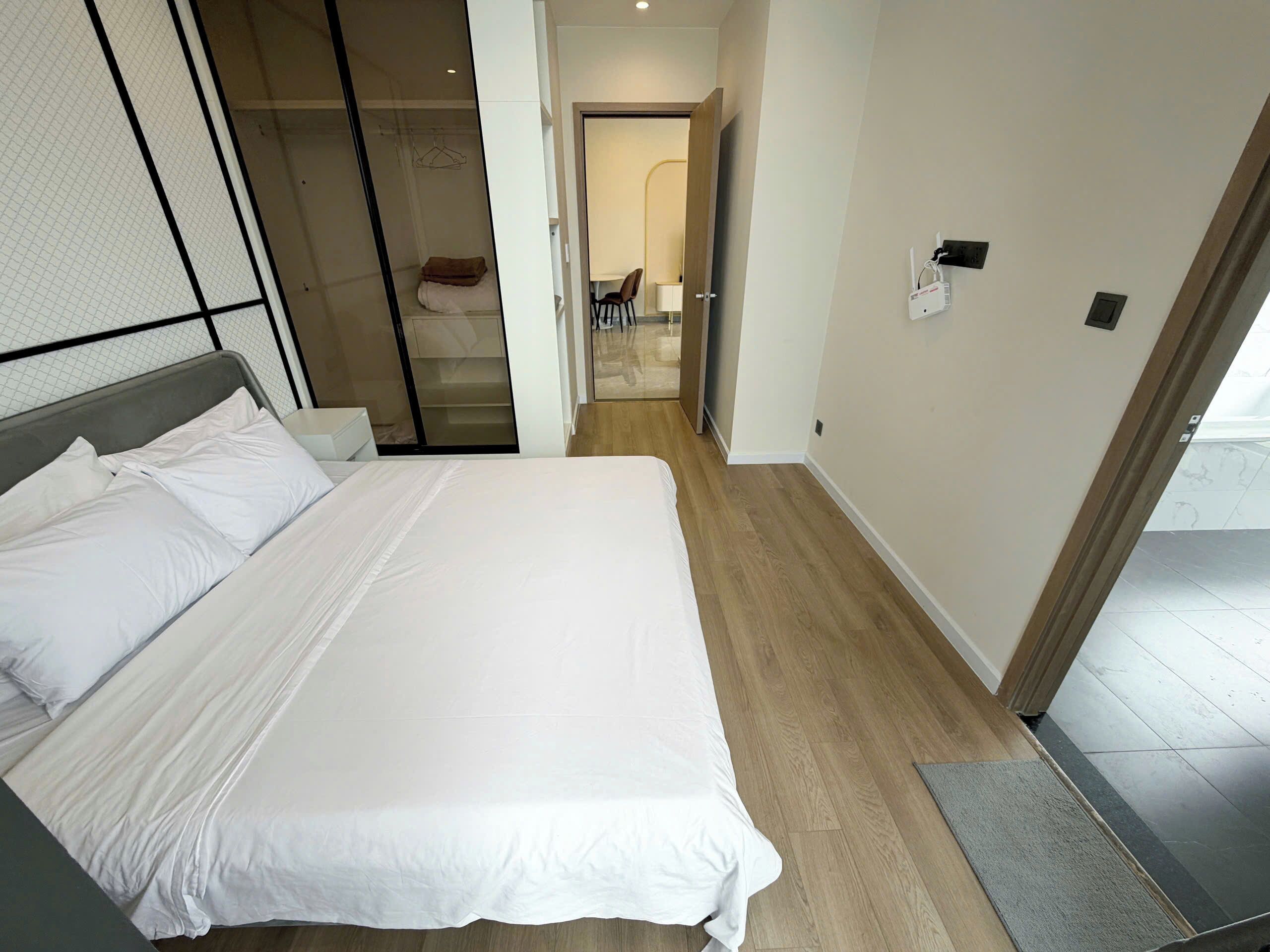 A hotel room with a bed, a walk-in closet, and a bathroom visible through an open door.