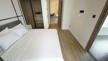 A hotel room with a bed, a walk-in closet, and a bathroom visible through an open door.