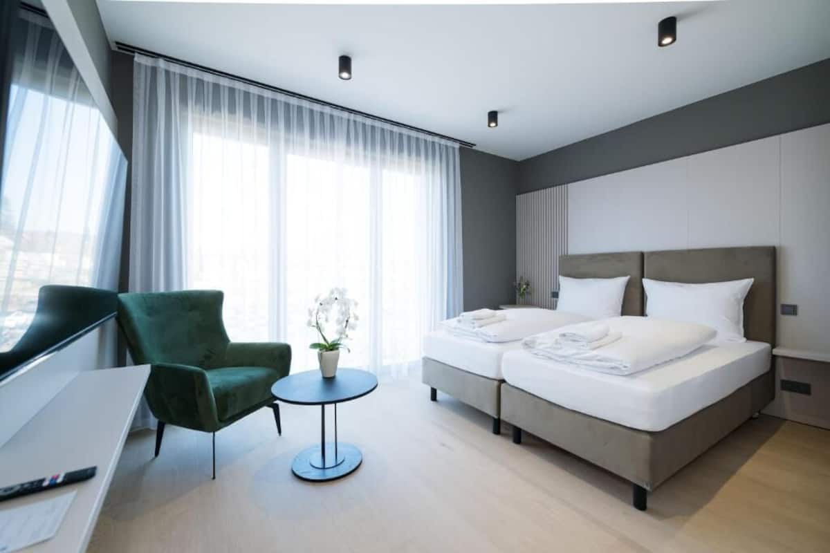 Una habitación de hotel con una cama, un escritorio, una silla y una mesita.