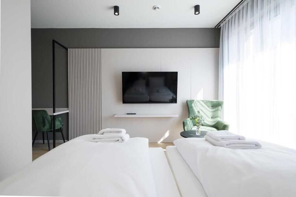 Een moderne hotelkamer met een bed, een televisie, een bureau en een stoel.