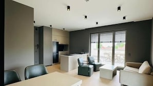 A modern interior with a dining area, kitchen, and seating space. - Taunus Suites (Oberursel (Taunus))