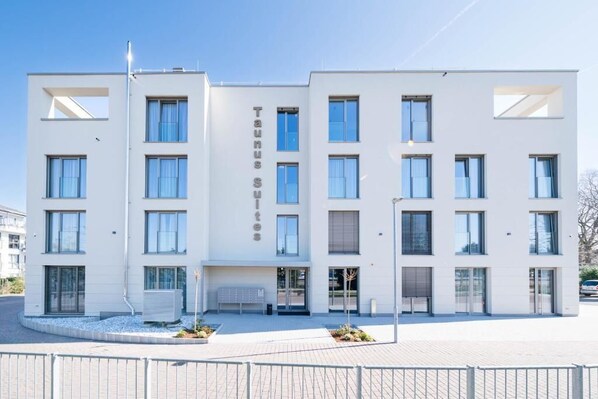 A modern building with a name sign 'Taunus Suits'.