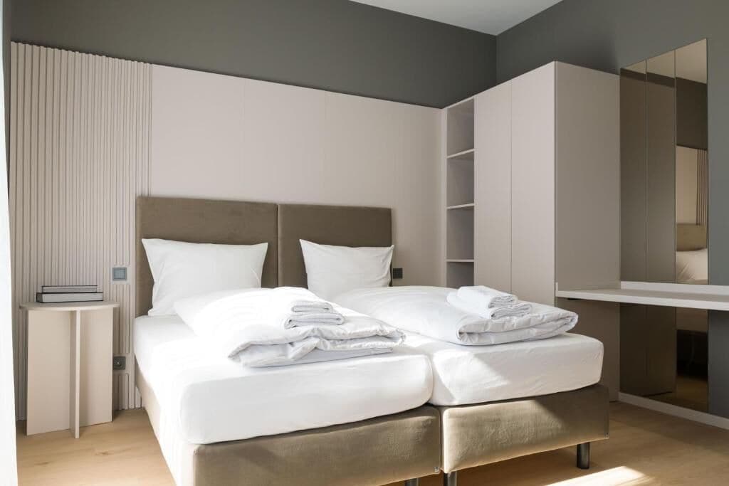 Un dormitorio moderno con cama, mesitas de noche y armario empotrado.