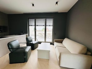 Ein modernes Wohnzimmer mit einer Couch, einem Couchtisch und einem Fernseher.