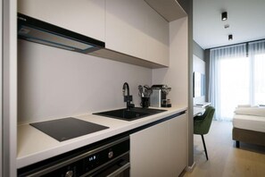 A modern kitchen with a built-in dishwasher, a coffee machine, and a kettle.