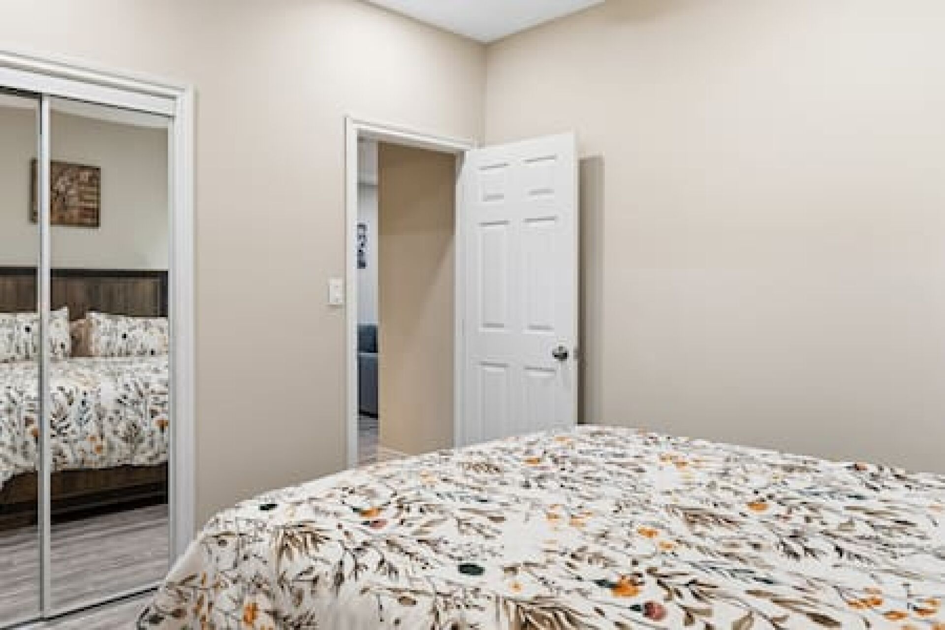 A bedroom with a bed, a wardrobe, and a door.