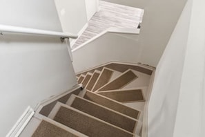 Un escalier au design géométrique original, des murs blancs et une main courante.