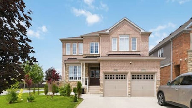 A two-story house with a garage, a driveway, and a car parked in the driveway. - Dilalla Residence -The Hidden Vine Retreat (Niagara Falls)