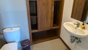 A bathroom with a toilet, a sink, and a wooden cabinet. - Room-a Quiet Room With Balcony in the he (Ubud)