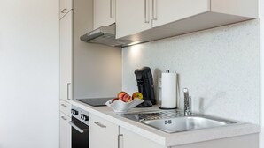 Eine moderne Küche mit Backofen, Kaffeemaschine und Spüle.