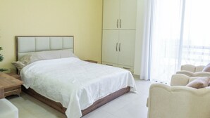 A bedroom with a bed, a wardrobe, a desk, and a chair. - Saint Paul Guesthouse (Zahlé)