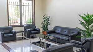 A modern lobby with a sofa set, a coffee table, and potted plants. - Saint Paul Guesthouse (Zahlé)