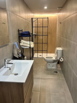 Ein Badezimmer mit Waschbecken, Toilette und Duschkabine.