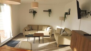 Uma sala de estar moderna com um sofá, mesa de centro e um armário de madeira.