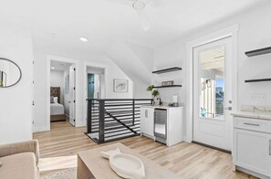 Eine moderne Küche mit Geschirrspüler, ein Essbereich mit Tisch und Stühlen, eine Treppe mit Geländer und ein Blick durch eine Tür.