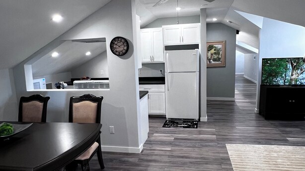 A modern kitchen with white cabinets, a refrigerator, and a ceiling fan. - Charming 3-bedroom house in adorable Bodden Town with AC (Bodden Town)