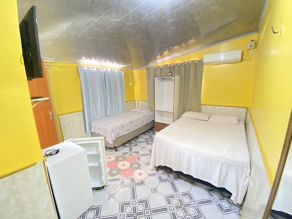 Ein gemütlicher Raum mit Bett, Schrank, Spiegel und kleinem Tisch.