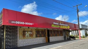 A building with a red awning, a sign for 'Hotel & Restaurante Mamá Quero,' and a contact number (91)98145-9000.