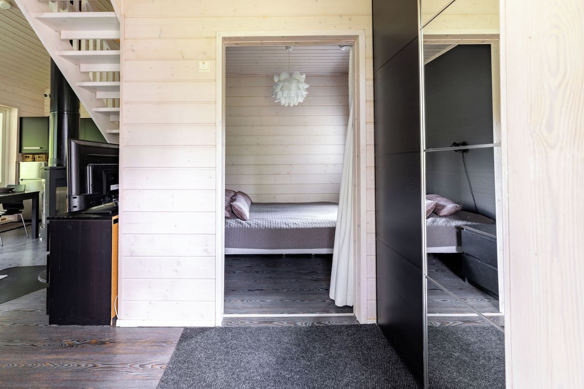 A compact room with a bed, a small table, and a chair.