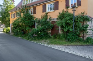 Un immeuble résidentiel avec un mur en pierre, une rue pavée et un lampadaire.