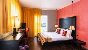 Habitación de hotel con cama, escritorio, silla y dos lámparas.