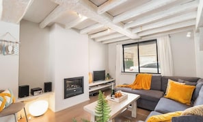 A living room with a fireplace, sofa, and coffee table. - Duinhalm - located in the heart of Nieuwpoort (Nieuwpoort)