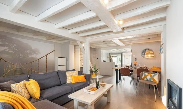 A modern living room with a sofa, coffee table, and dining area with chairs. - Duinhalm - located in the heart of Nieuwpoort (Nieuwpoort)