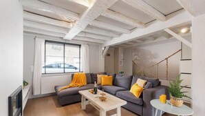 Una sala de estar moderna con un sofá, una mesa de centro y una planta colgante.