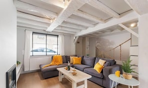 Ein modernes Wohnzimmer mit einer Couch, einem Couchtisch und einer hängenden Pflanze.