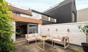 A modern house with a patio area featuring a sofa set and a table. - Duinhalm - located in the heart of Nieuwpoort (Nieuwpoort)