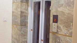 An elevator with a marble wall, a digital display showing the number 2, and a 'Frame Size' label. - Hotel Shree Krishna Inn (Ujjain)