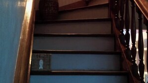 A staircase with a wooden handrail and a vase with sticks on the wall. - Beachfront home in Douarnenez Bay (Plonévez-Porzay)