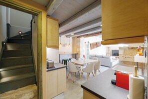 Una cocina moderna con comedor, una escalera y una sala de estar.