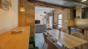 Un interior acogedor con una mesa de comedor de madera, un sofá y una zona de cocina.