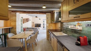Una cocina con armarios de madera, una encimera y una cafetera roja.