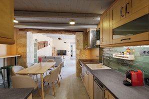 A kitchen with wooden cabinets, a countertop, and a red coffee maker.