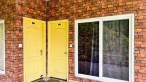 A brick building with two yellow doors and a large window. - Shubh Hotel (Mussoorie)