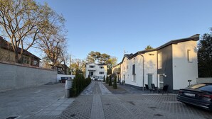 Una calle residencial con casas, un sendero empedrado y coches estacionados.