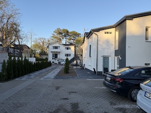 Eine Wohnstraße mit einem weißen Gebäude, Hausnummer 10, und einem parkenden Auto.